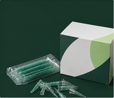 A box with a white and light green graphic design stands next to a clear plastic bag containing several green syringes, with a few loose green syringes scattered in front, all on a dark green background.